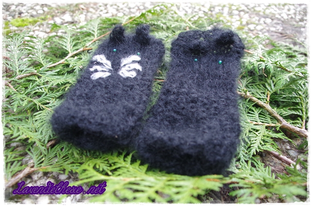 schwarze Pulswärmer liegen auf grünen Zweigen